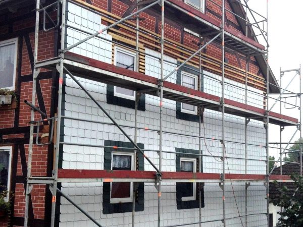 Gesamte Fassade eines Hauses mit weissen und schwarzen Schindeln